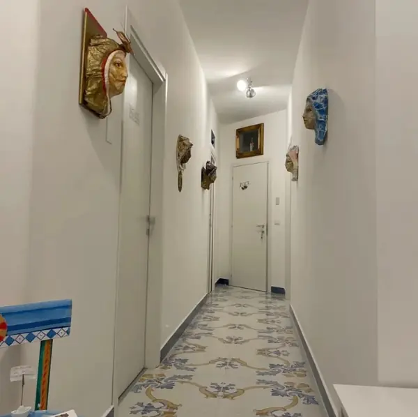 Corridor with majolica floor and artistic masks on the walls