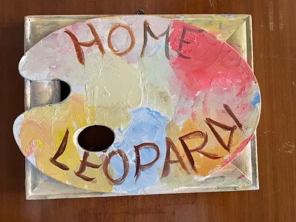 Hand-painted palette-shaped sign reading Home Leopardi